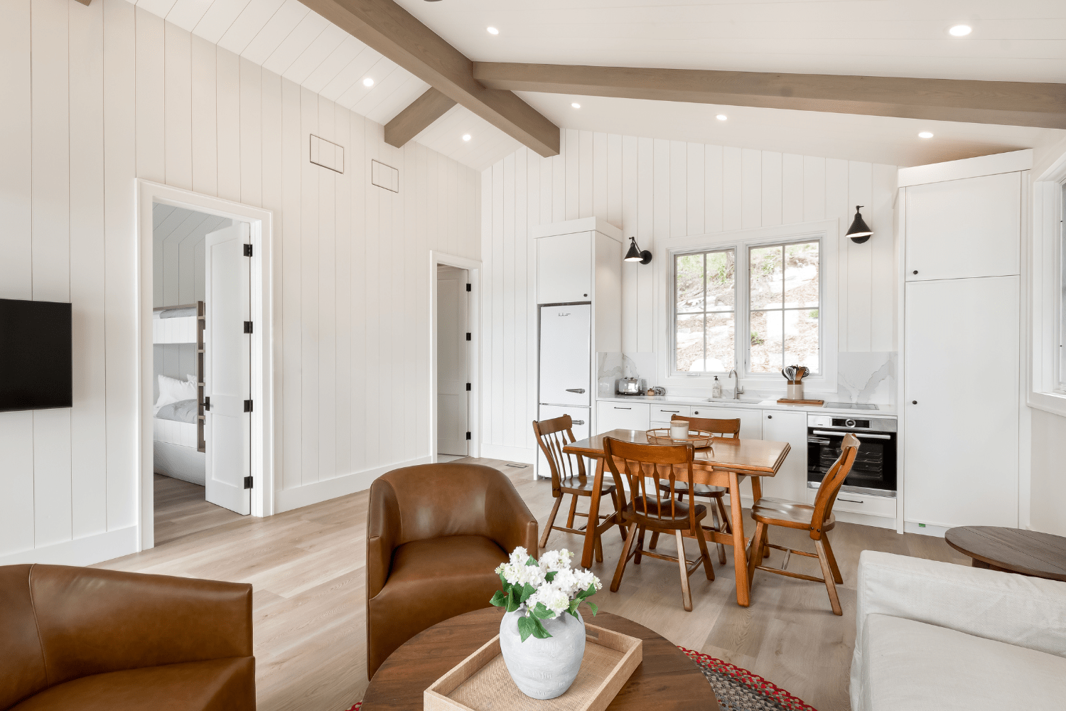 Cottage bunkie house design with white kitchenette