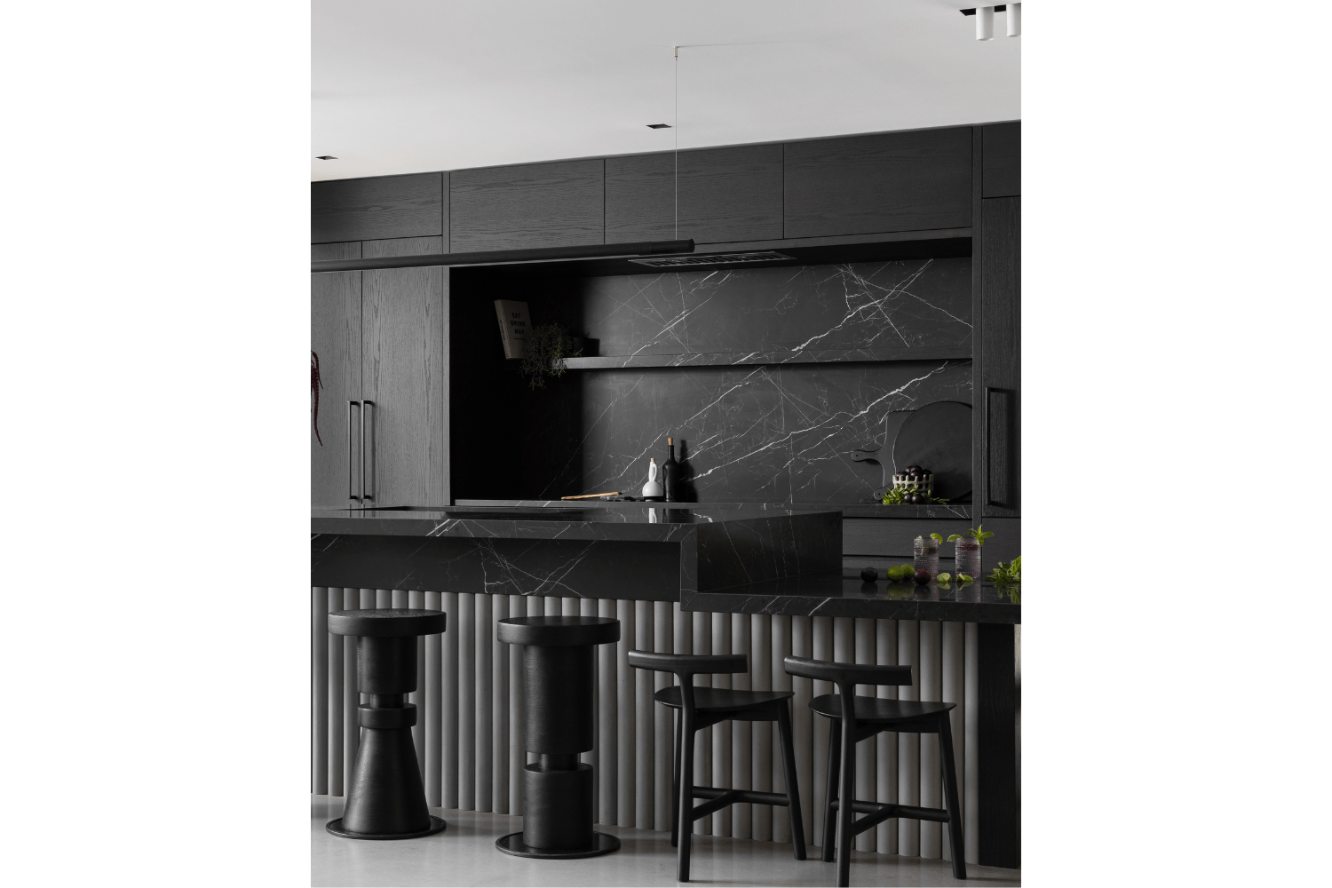 Two-tier kitchen island with reeded stone and black countertop