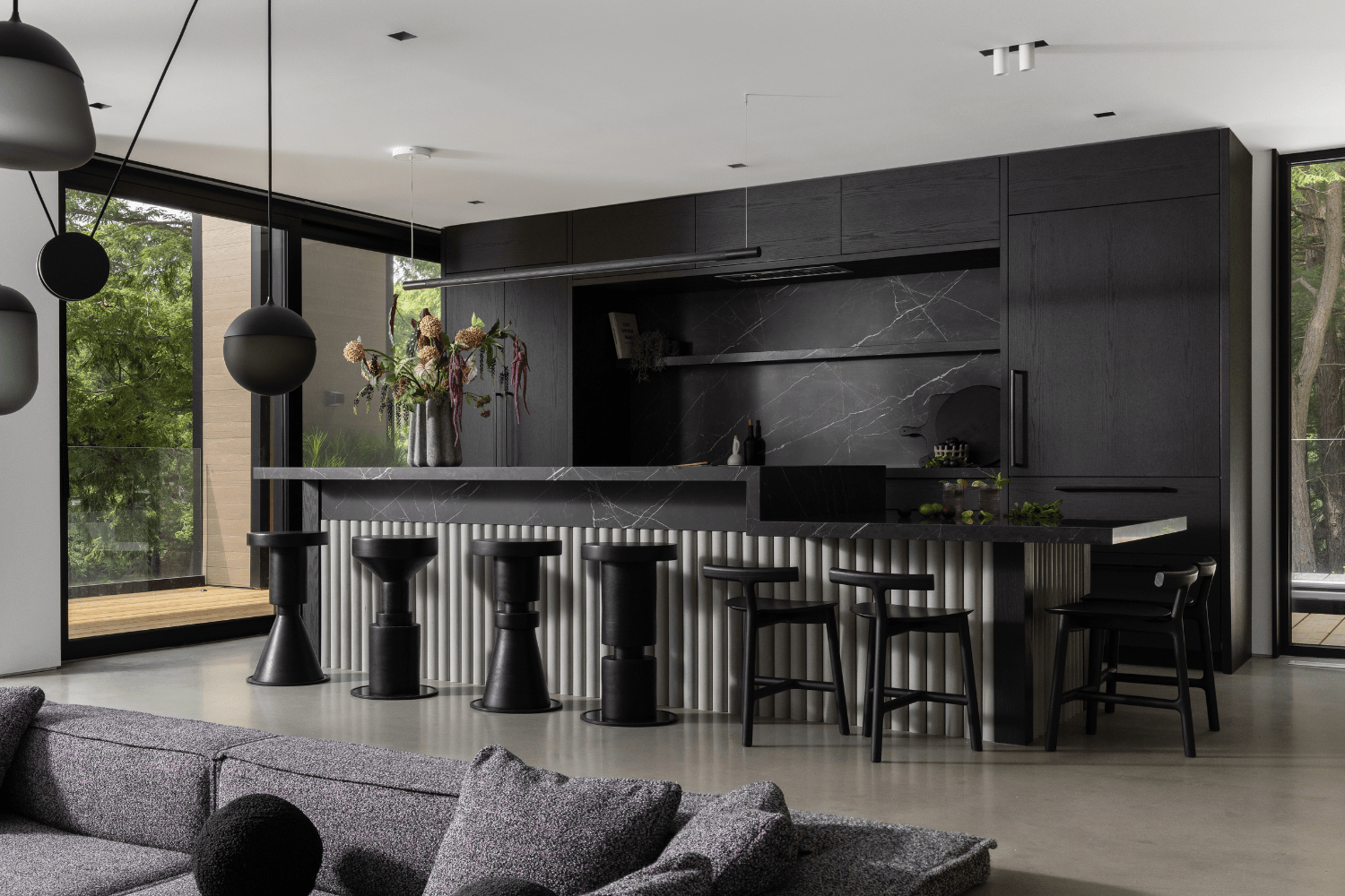 Contemporary black kitchen with reeded stone kitchen island