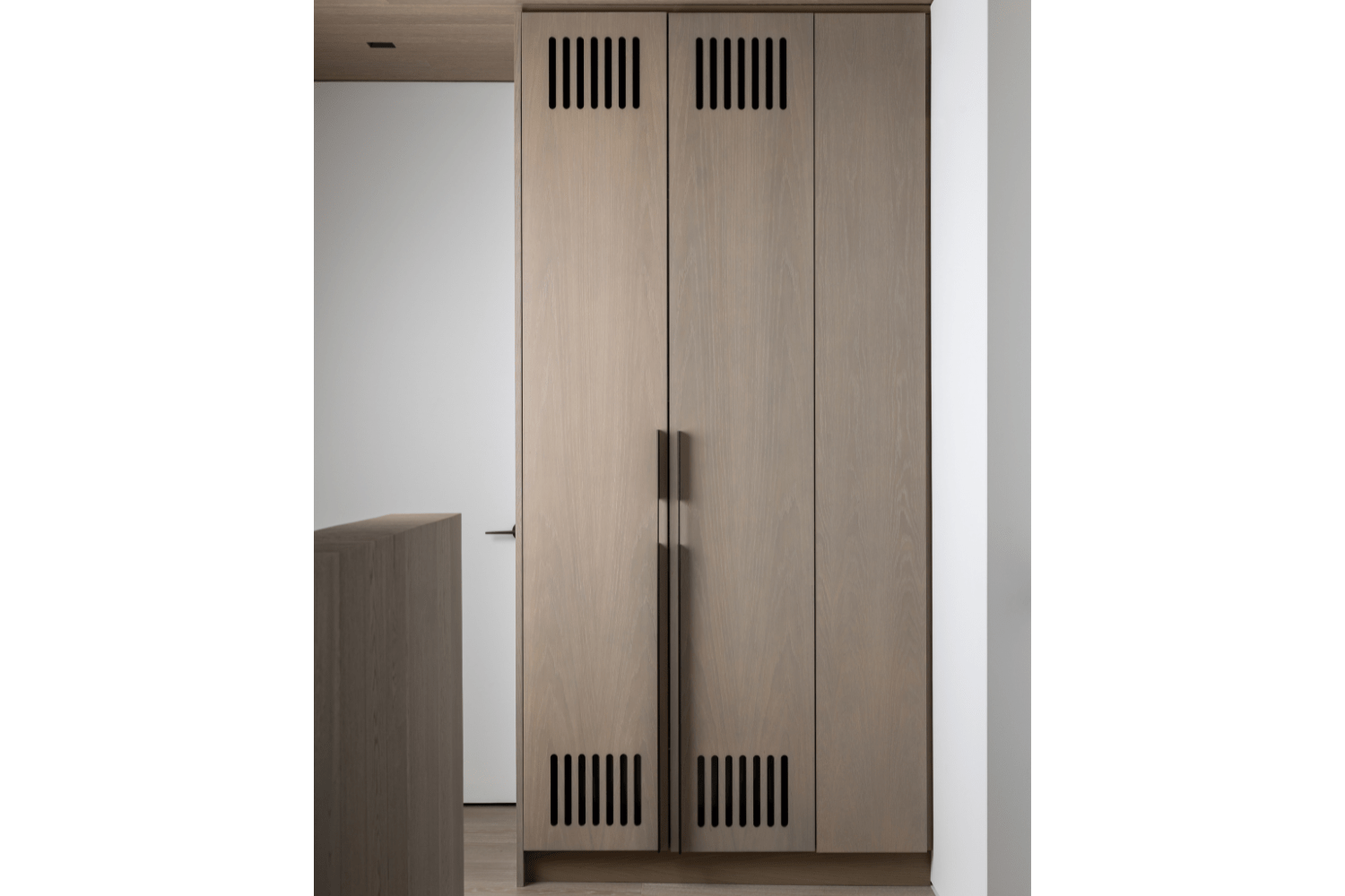 Compact laundry closet with vented white oak doors