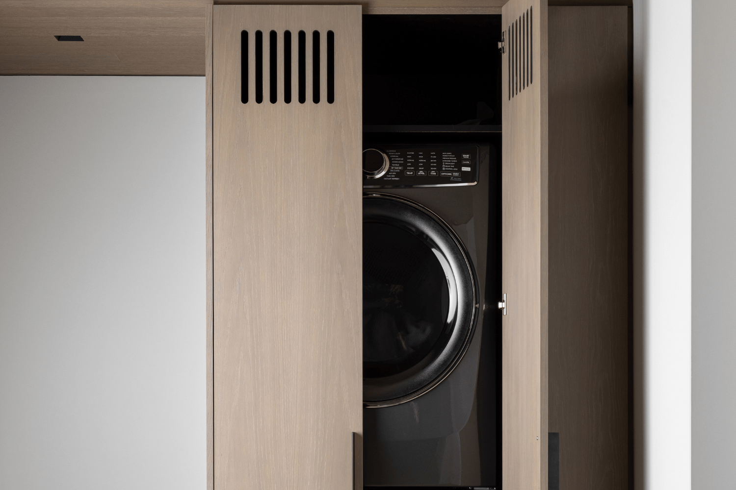 Laundry room closet with custom vented white oak doors