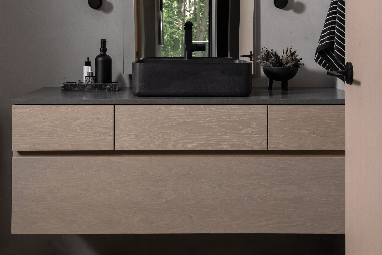White oak floating bathroom vanity with stone vessel sink