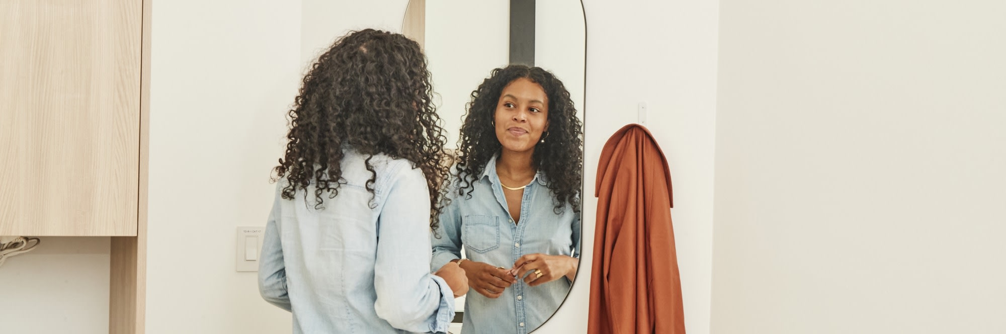 Patient standing and looking into mirror in treatment room.