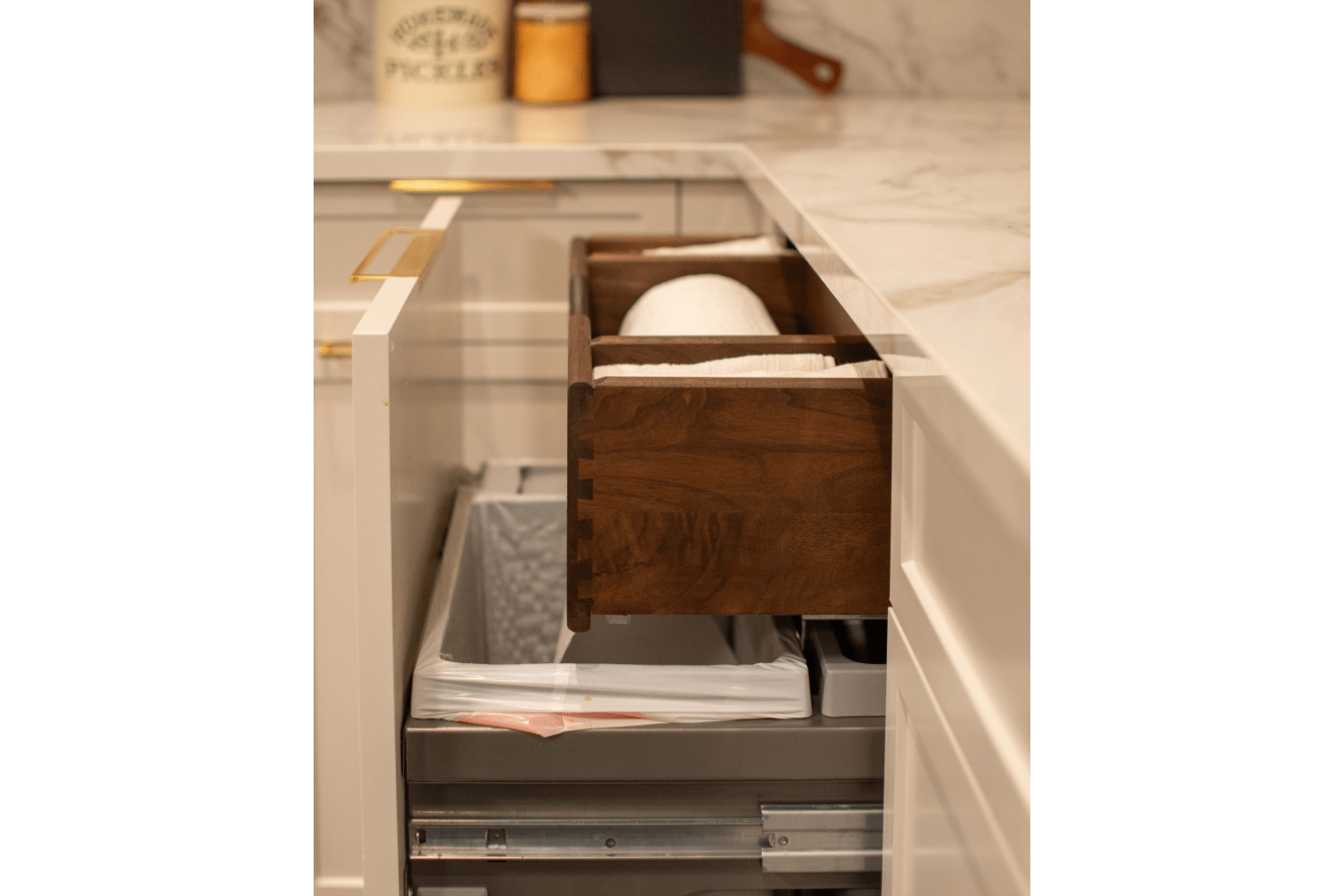 Custom paper towel drawer within pull-out garbage with walnut do
