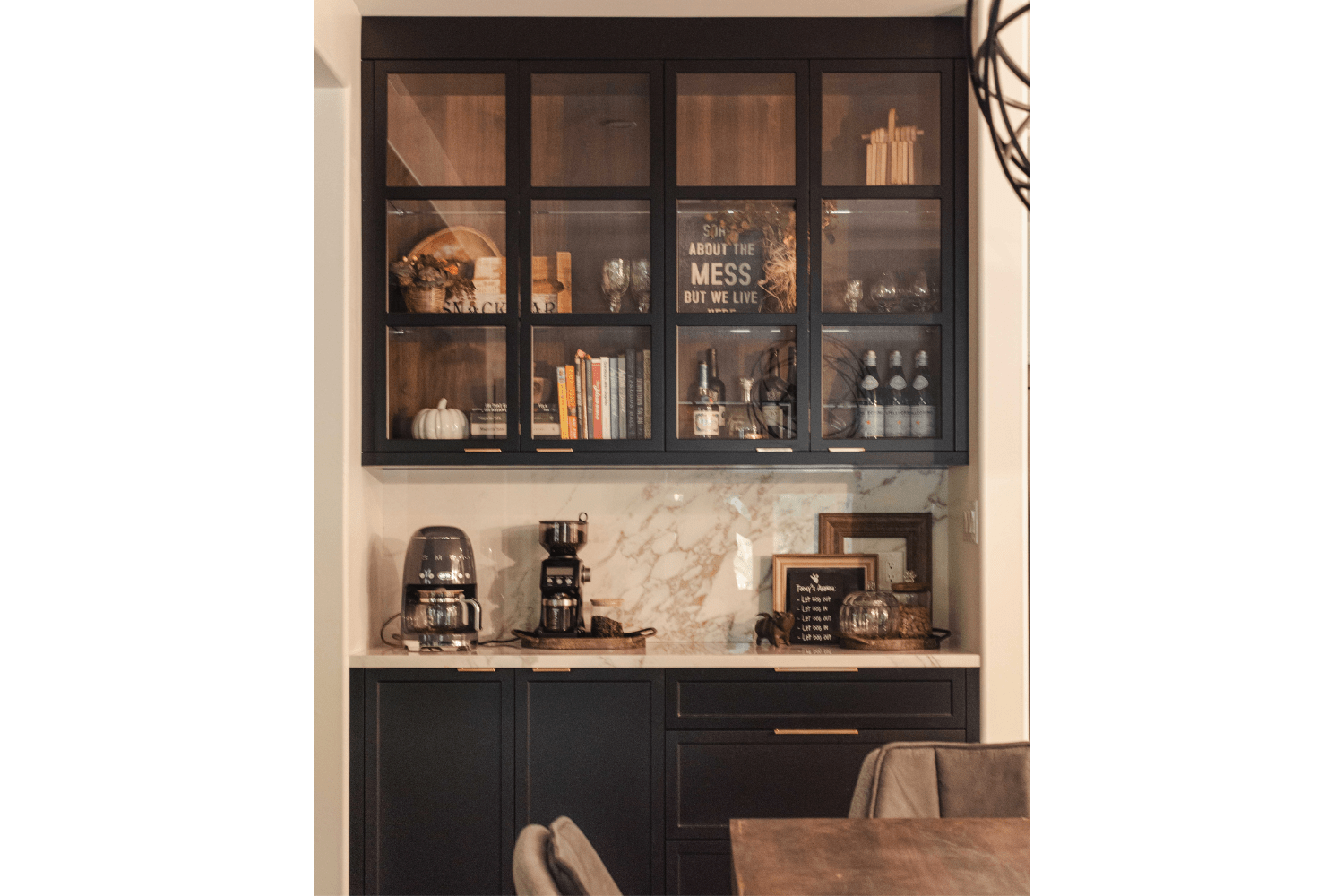 Dining room coffee bar with black cabinetry and upper glass fram