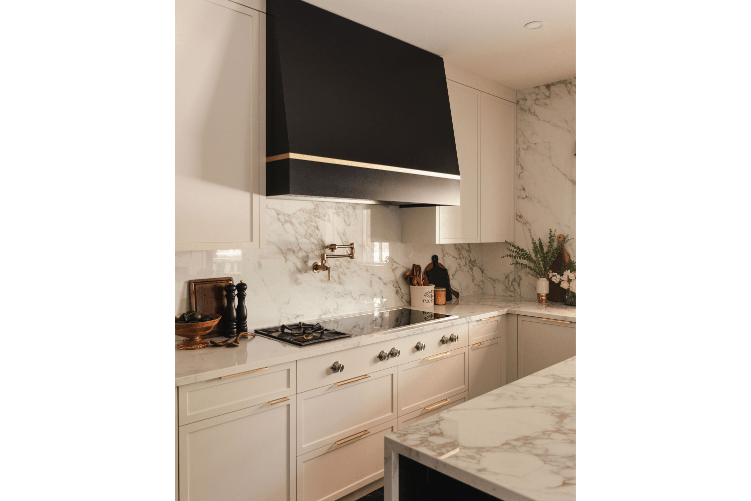 Custom black metal range hood with brass accent