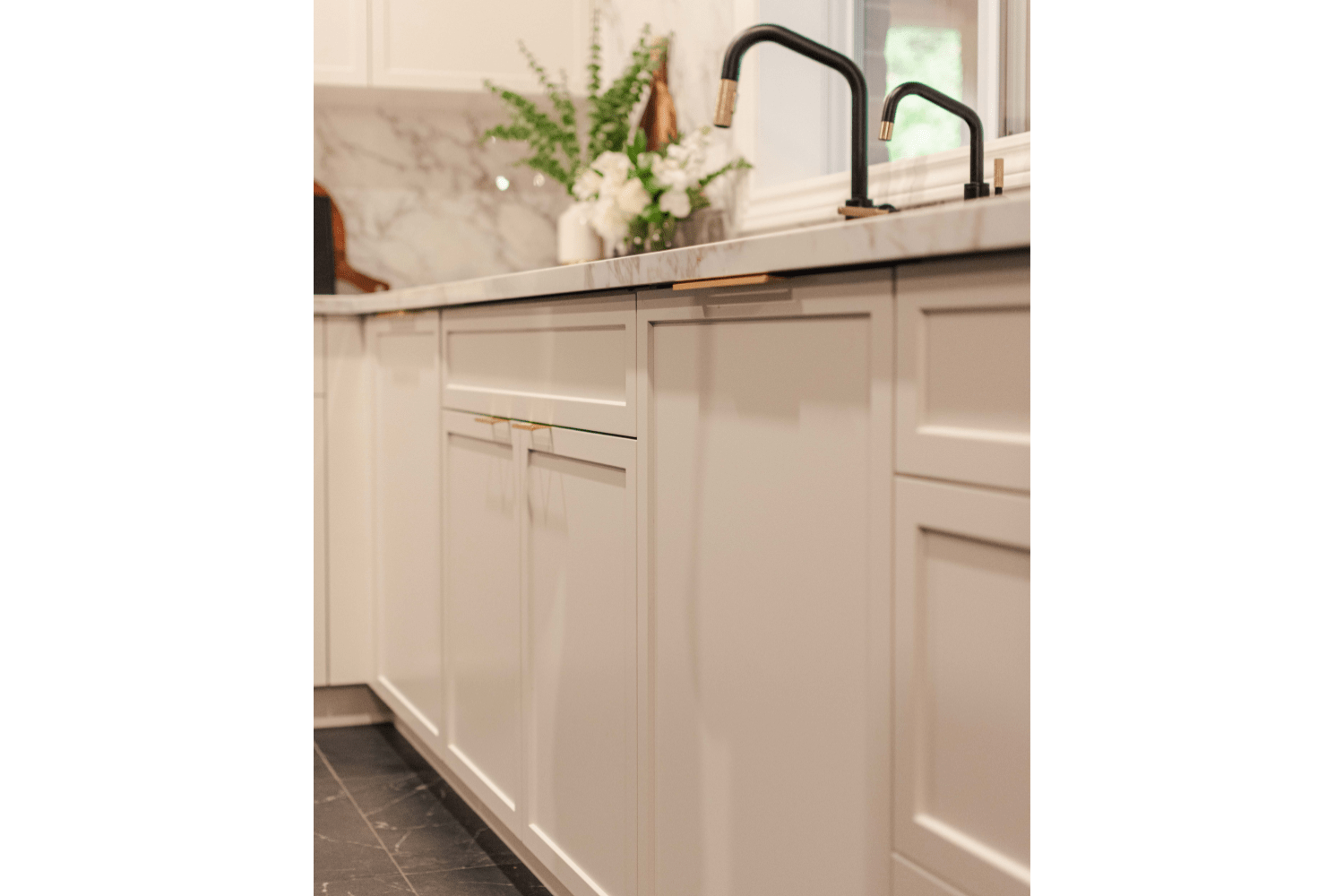 Custom cabinetry located by the sink with brass pulls