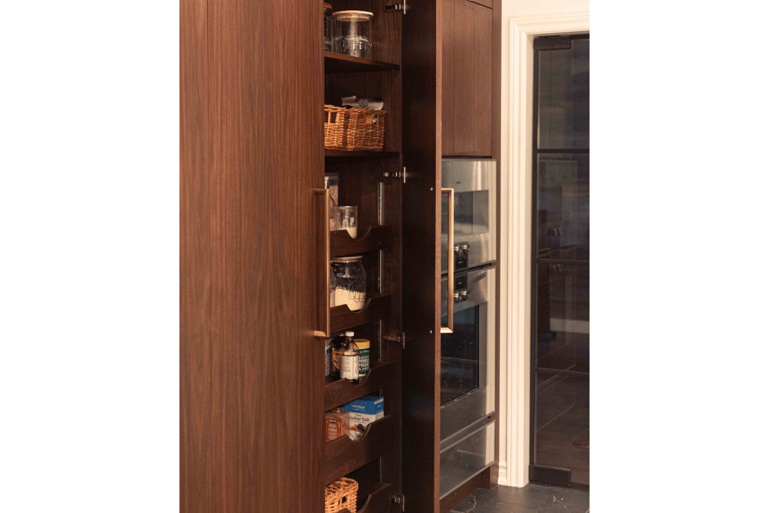 Custom floor to ceiling pantry crafted from walnut