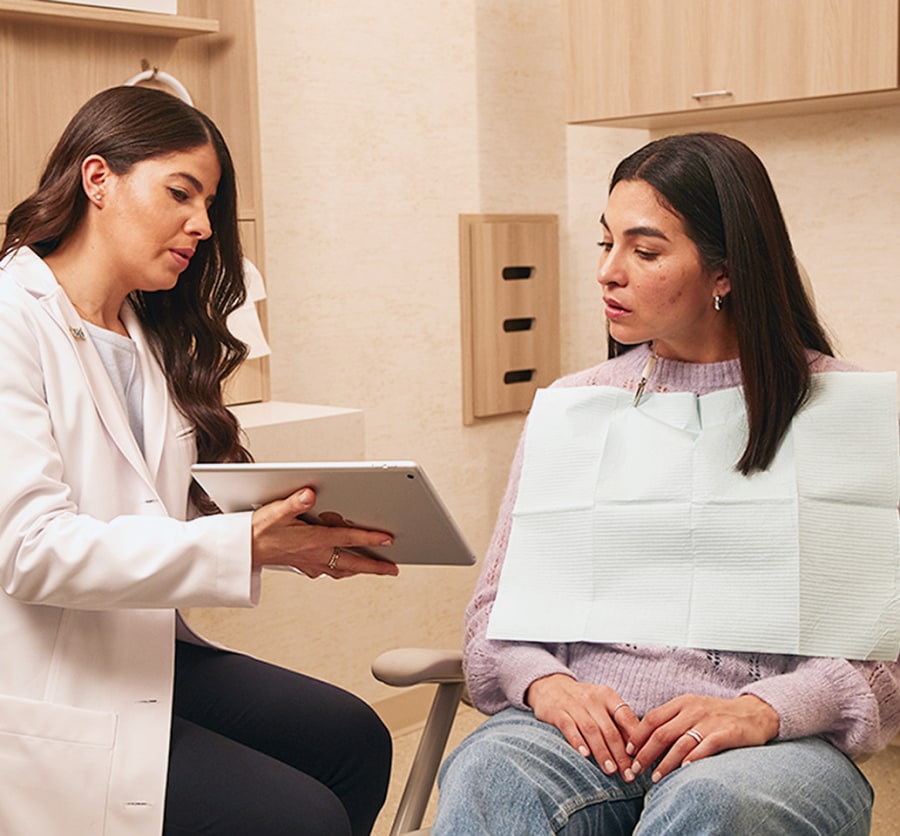 A team member shows a patient a tablet screen.