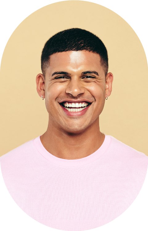 A man with a buzzcut is smiling.