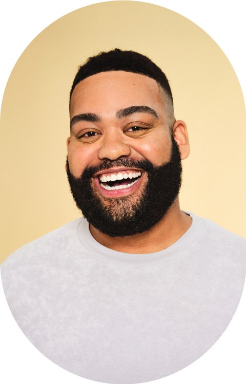 A man with a beard is smiling.