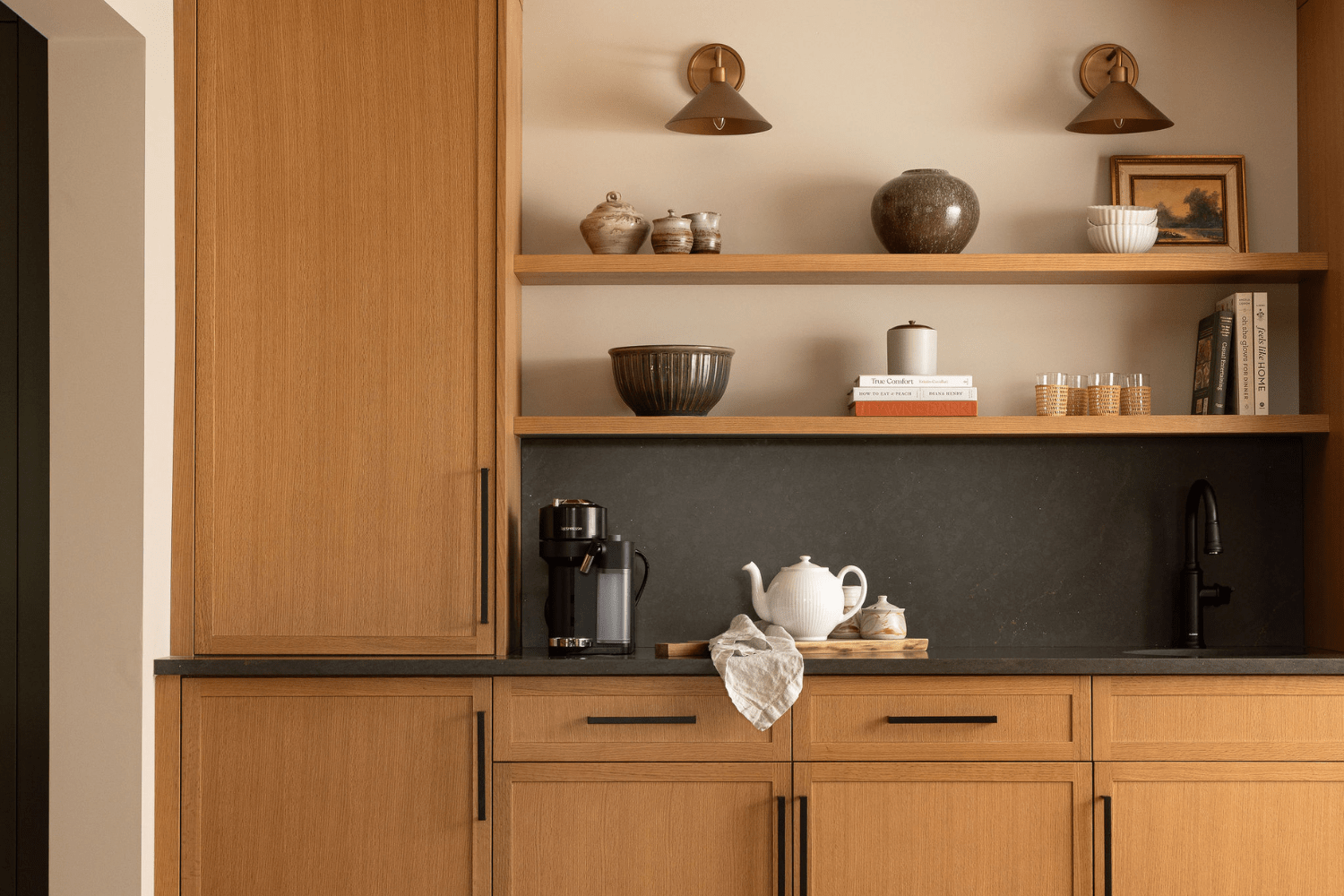 Dining room wet bar with red oak cabinets and black countertop