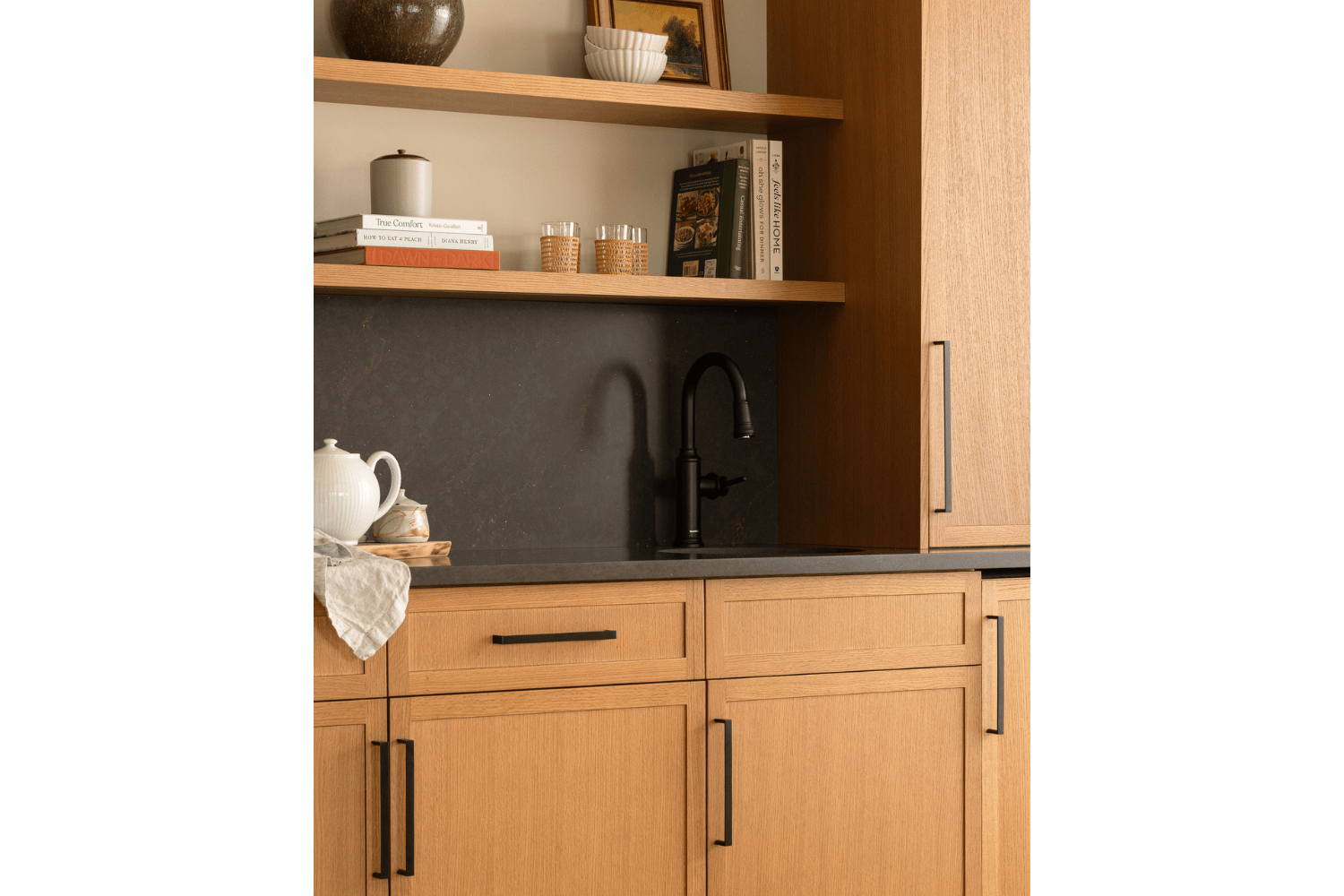 Wet bar design with red oak cabinetry and black countertop