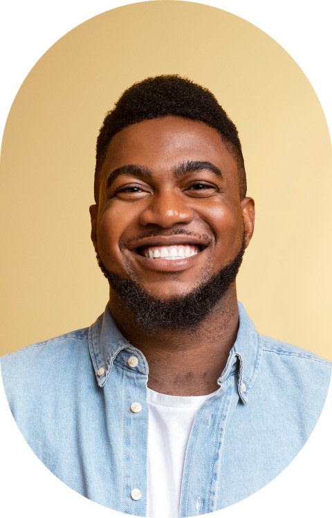 A man in a blue shirt is smiling with his eyes closed.