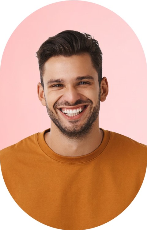 A man in an orange shirt is smiling.