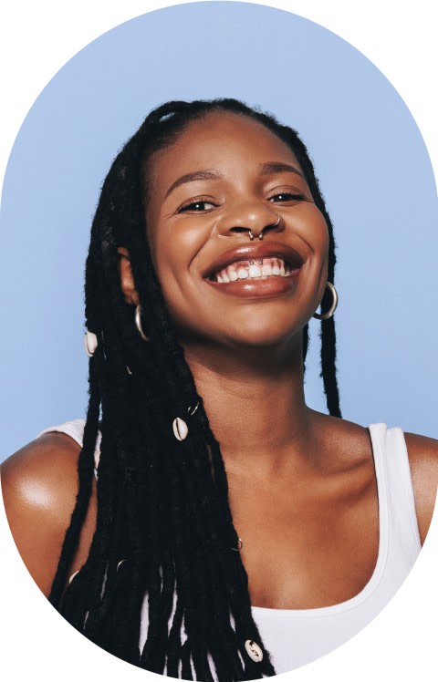 A young woman with long braids is smiling.