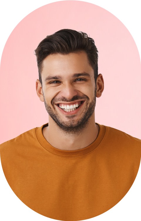 A man in a orange shirt is smiling.