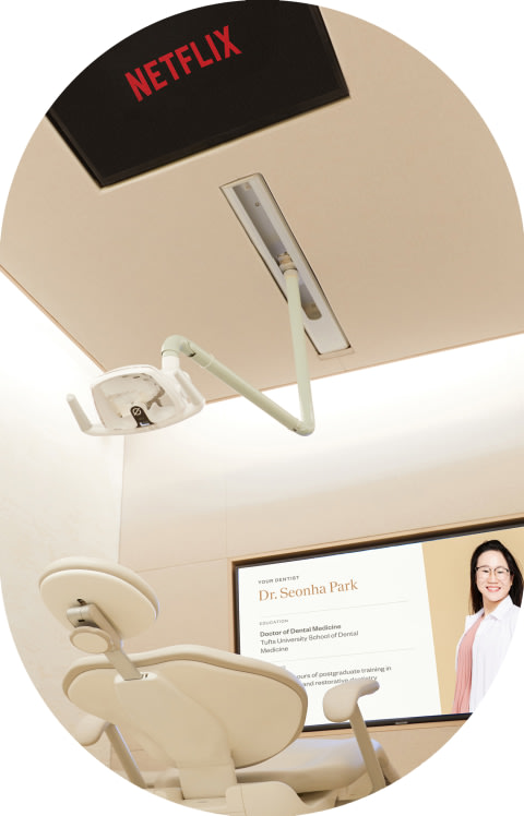 A dental chair with a screen on the ceiling showing Netflix.