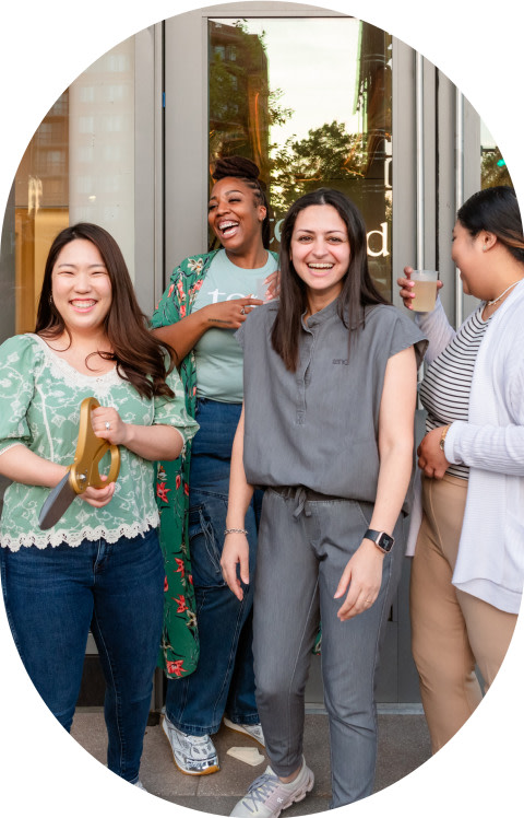 A group of employees is smiling outside a Tend grand opening.