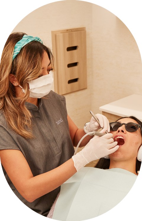 A Tend dental hygienist is working on a patient.