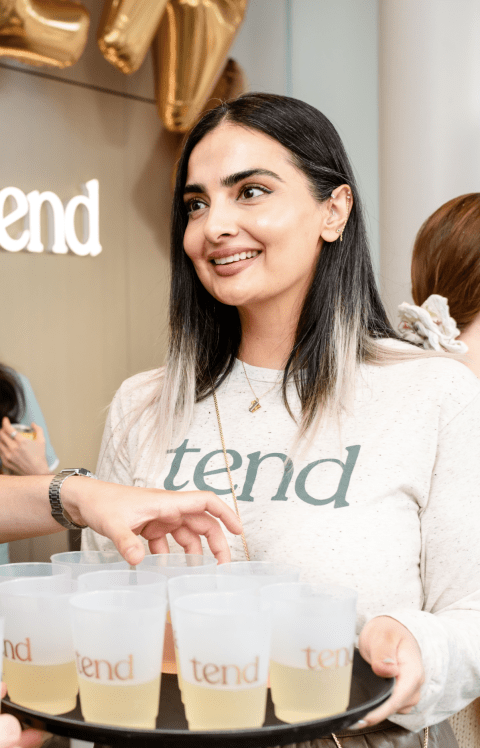 An employee in a Tend sweater is smiling.