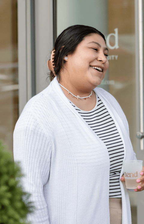 A Tend patient is smiling and holding a beverage.