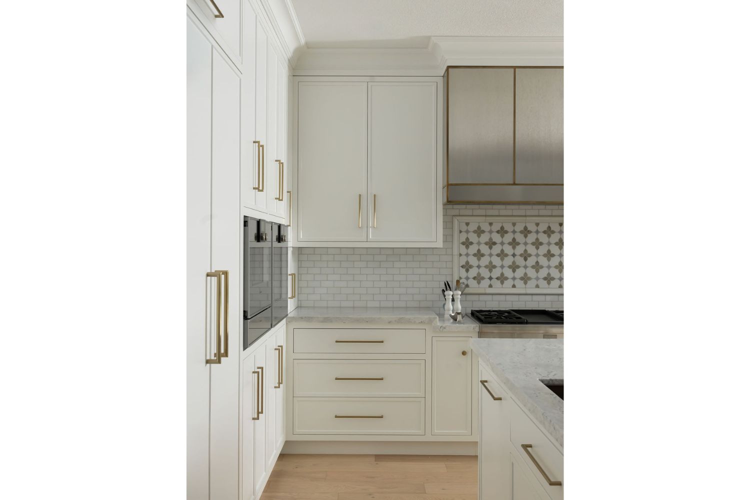 Custom transitional kitchen design with white cabinets and brass