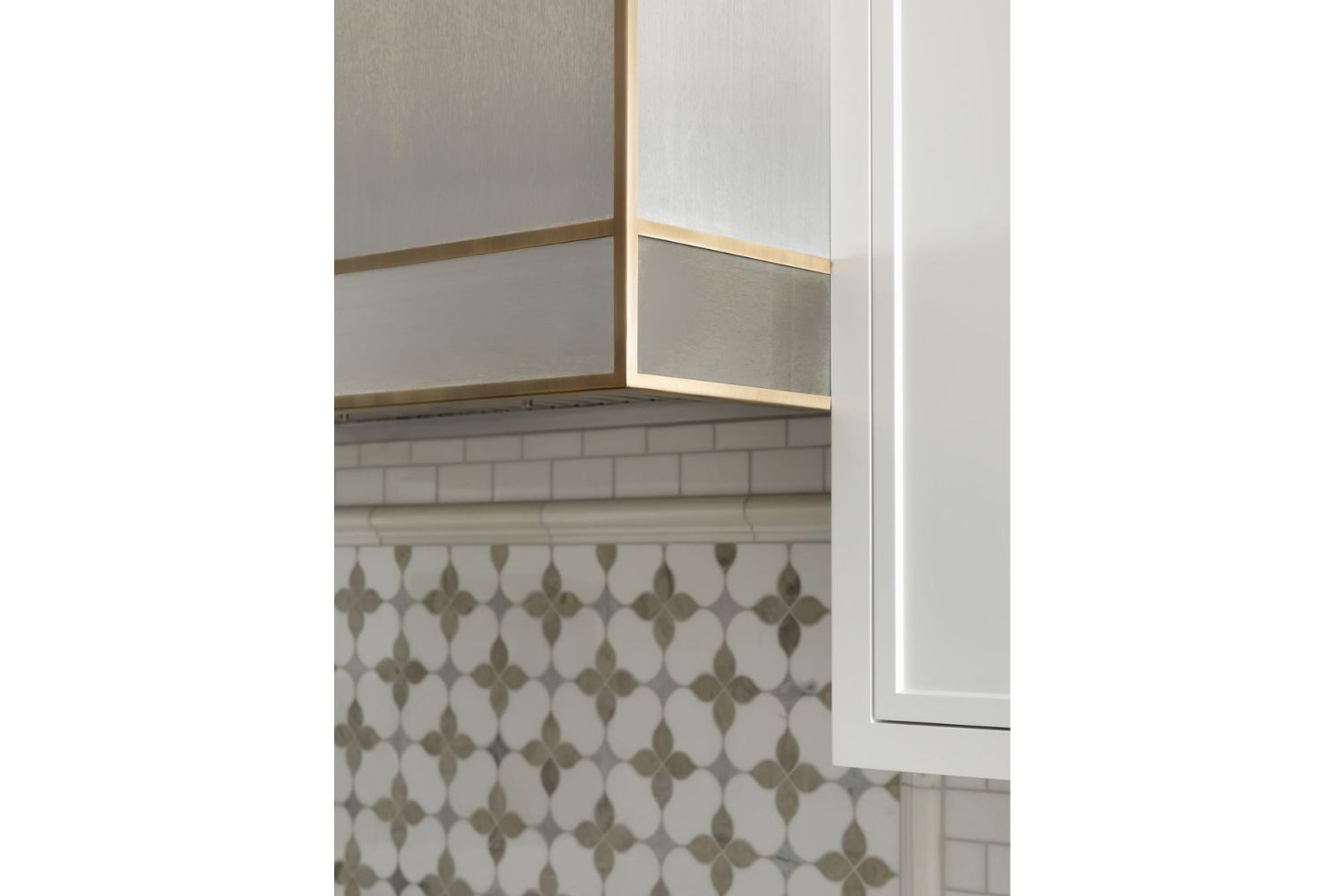 Custom stainless steel range hood with brass framing detail