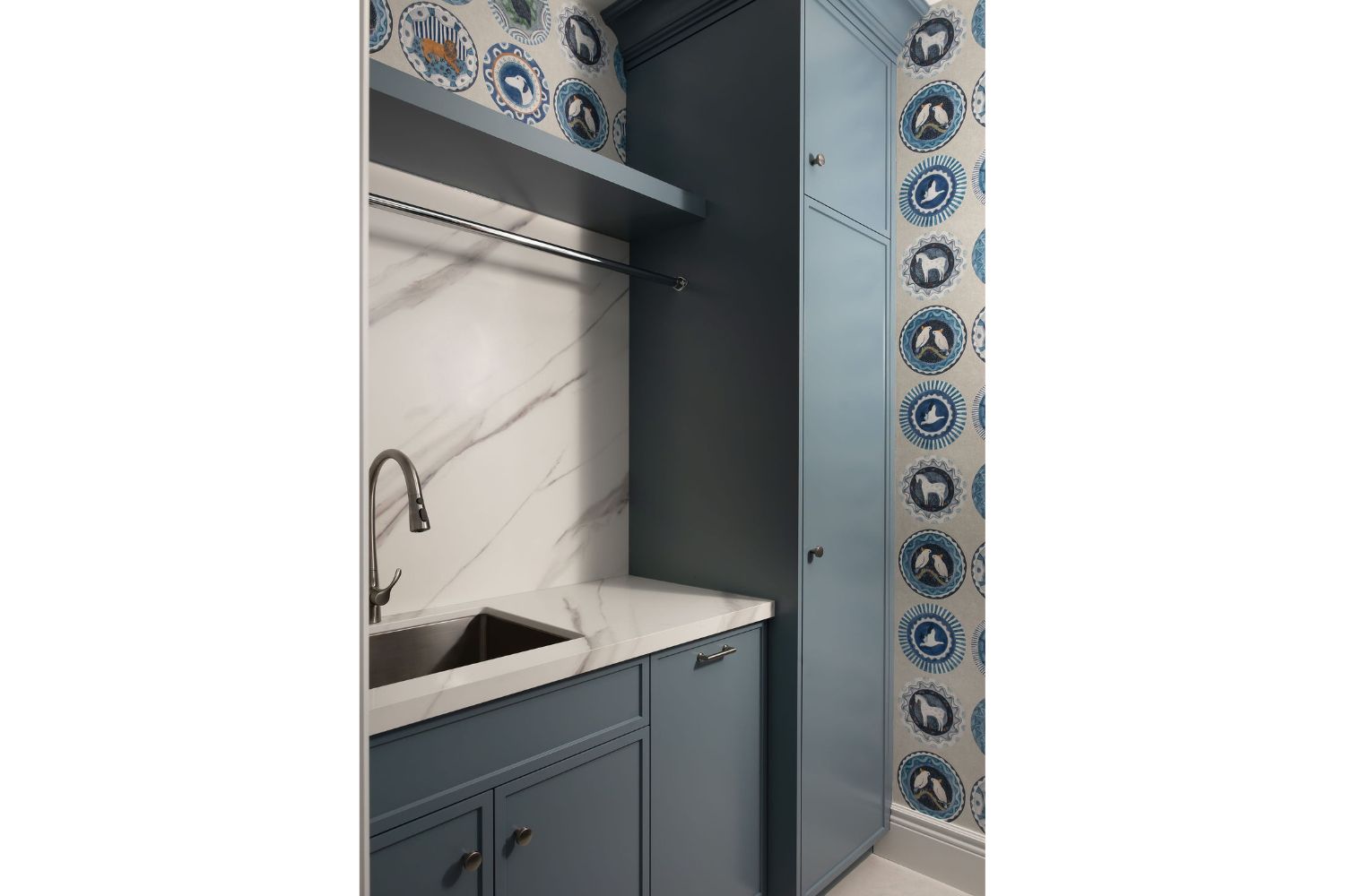 Custom blue laundry room with laundry sink and floor to ceiling