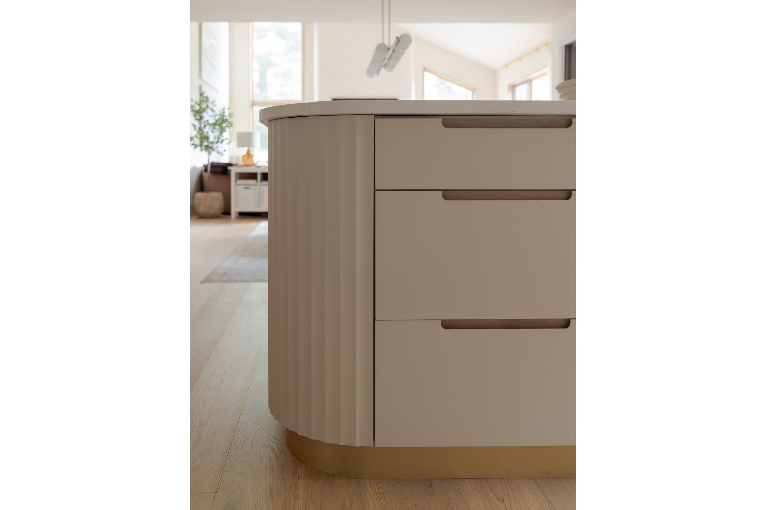 Fluted cream island with rounded corners and gold metal toe kick