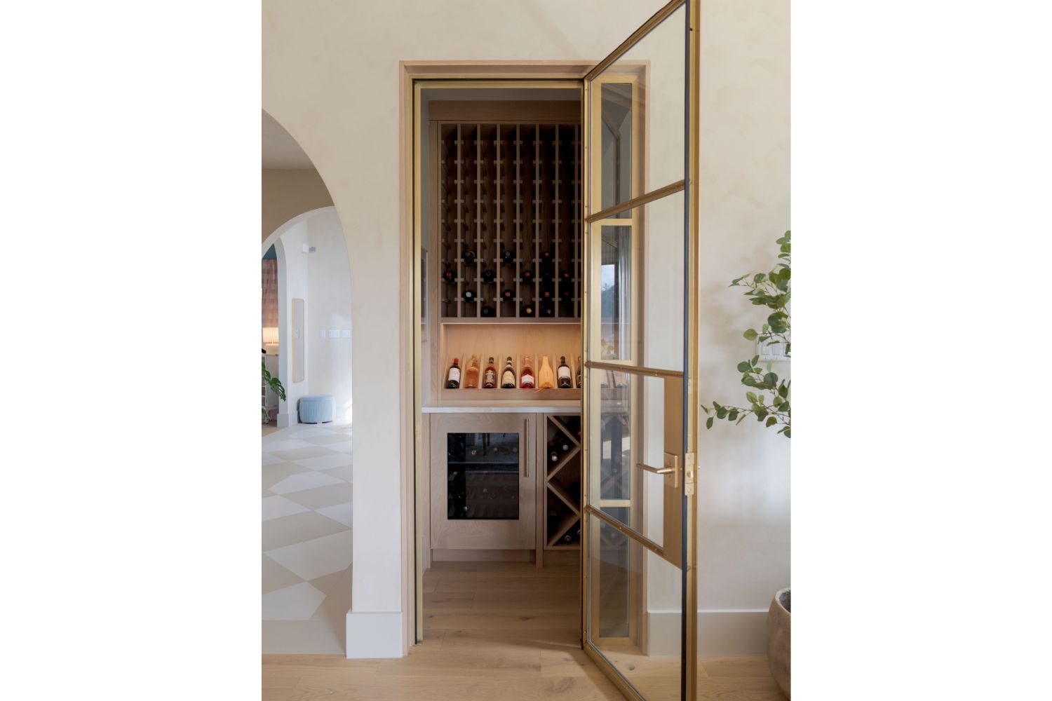 Luxury wine room tucked beind gold framed glass door