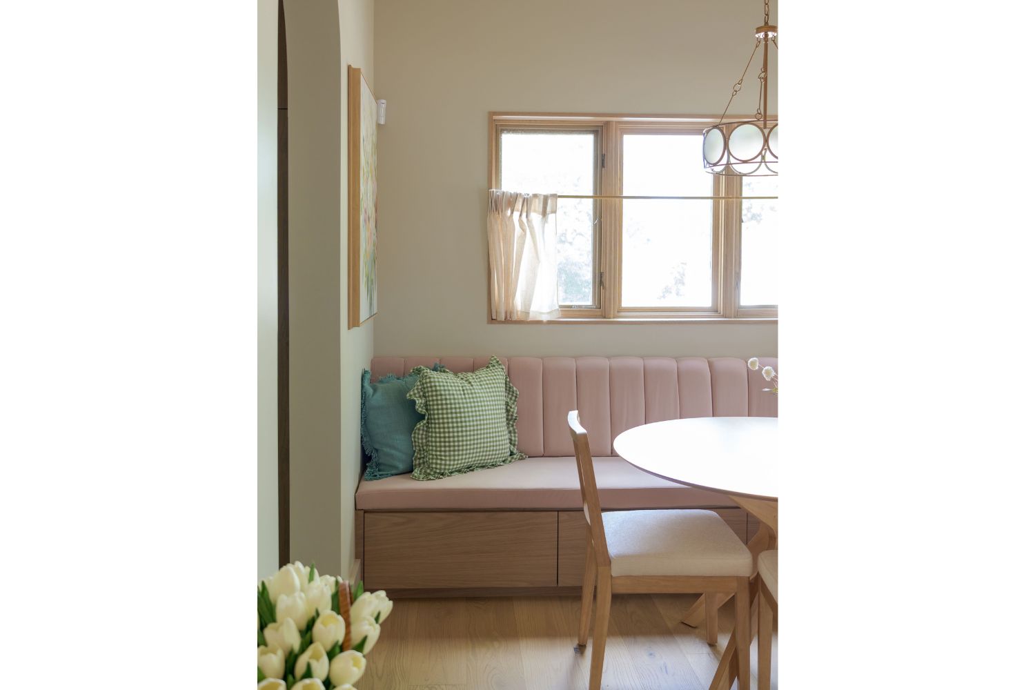 Custom pink upholstered banquette with tufted back white oak bas